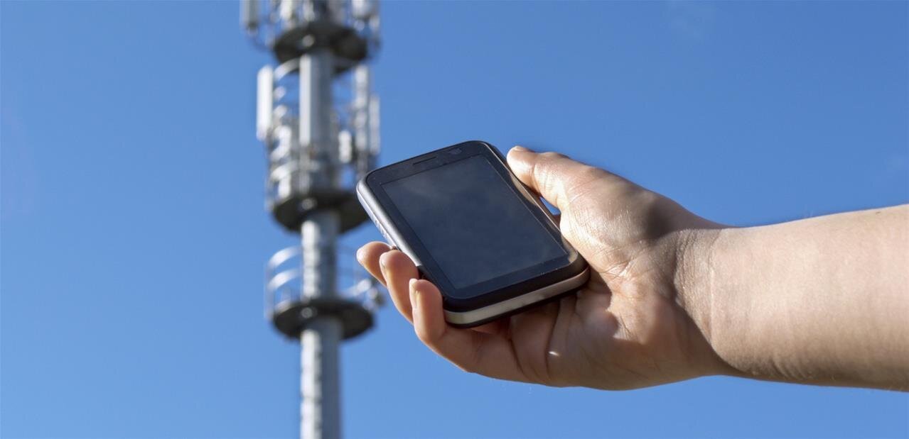 Medewerker bedient een push-to-talk-toestel bij een zendmast